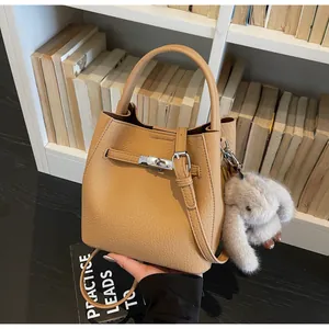 Dettaglio borsa a secchiello in pelle kaki con chiusura argento e ciondolo a coniglio