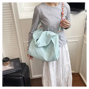 Dettaglio della borsa tote azzurra con tracolla in corda intrecciata colorata