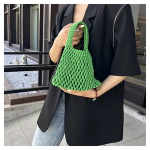 Detalle del bolso de malla tejida verde hecho a mano con intrincados nudos de algodón