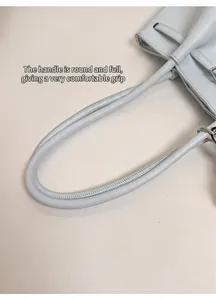 Detailaufnahme der glatten runden Griffe und Nähte an der hellblauen Shopper-Tasche