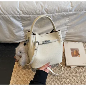 Dettaglio della borsa a secchiello in pelle martellina bianco sporco con ciondolo a forma di coniglio