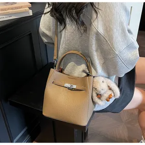 Dettaglio borsa in pelle martellata kaki con chiusura argento e ciondolo a forma di coniglio