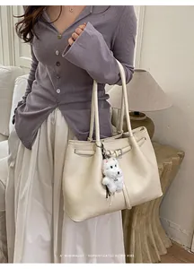 Schicke cremefarbene Tragetasche mit Hundeanhänger und Lederriemendetail im minimalistischen Stil