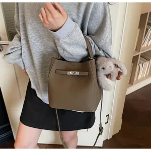 Dettaglio borsa a secchiello in pelle marrone con chiusura argento e ciondolo a coniglio