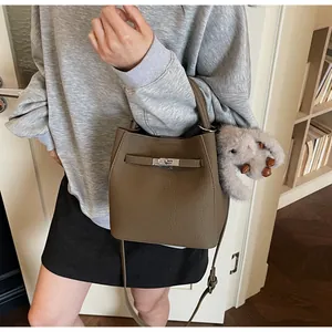 Dettaglio borsa a secchiello in pelle marrone scuro con chiusura argento e charm