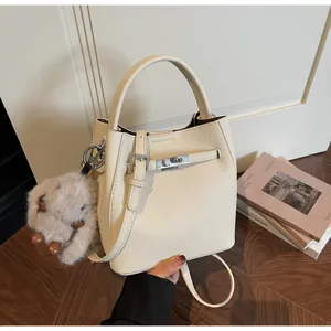 Dettaglio della borsa a secchiello in pelle litchi bianco sporco con fibbia in argento
