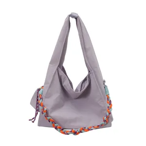 Borsa tote lilla minimalista con tracolla intrecciata a contrasto arancione e blu