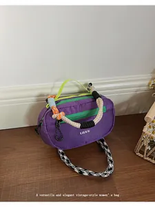 Dettaglio macro della borsa Boston in nylon viola con zip verde e tracolla a scacchi