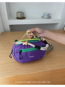 Dettaglio borsa Boston in nylon viola con manico in corda intrecciata e cerniera verde
