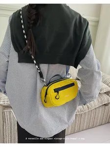 Dettaglio della borsa a tracolla in nylon giallo con cinturino pied de poule