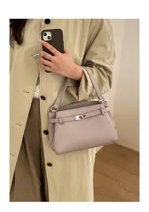 Detail of light purple pebbled leather handbag with silver clasp on beige trench coat