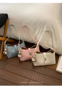 Detailed texture of litchi grain leather bags with metal buckles and plush charms
