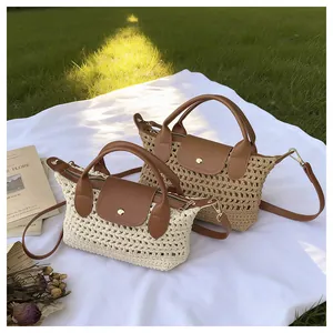 Detail van handgeweven stro schoudertassen met lederen handvatten in beige en kaki