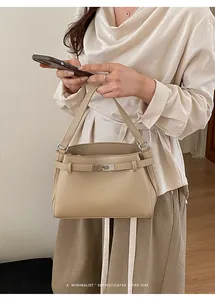 Detail of beige pebble leather handbag with silver buckle and elegant top handle