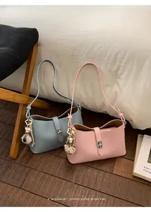 Detail of lychee textured leather bags with metal twist locks and floral charms