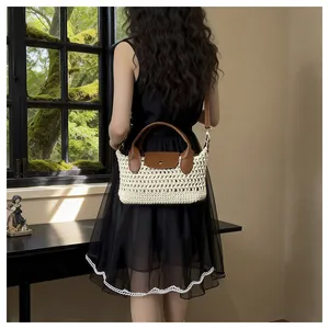 Chique crème geweven crossbodytas met bruine leren accenten in een lifestyle binnenomgeving