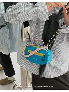 Dettaglio della borsa Boston color alzavola con patta gialla e tracolla a pois