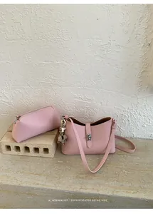 Pink lychee grain leather handbag set with silver twist lock and furry charm detail