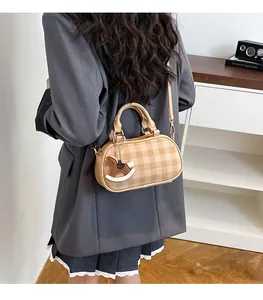 Detalle de bolso bandolera a cuadros con un lindo accesorio de charm de caballo en cuero