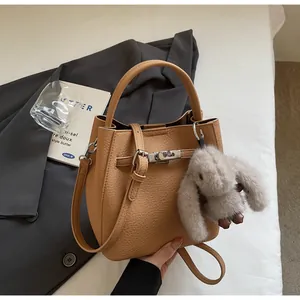 Dettaglio borsa a secchiello color cammello in pelle martellata con chiusura silver