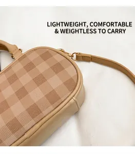 Close-up of khaki checkerboard pillow bag with leather handles and gold metal hardware