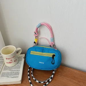 Mini borsa Boston blu in nylon con manici intrecciati colorati e tracolla alla moda