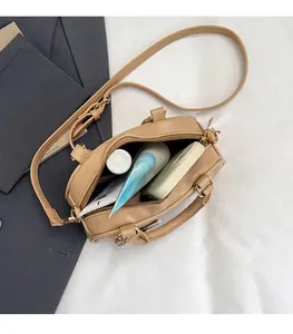 Spacious interior of a khaki leather satchel showing storage for phone and hand cream