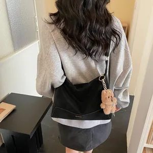 Minimalist black matte hobo bag with gold lettering and teddy bear charm for daily wear