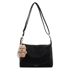 Retro black matte crossbody bag with adjustable strap and cute plush dog charm