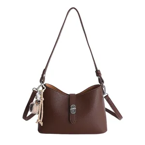 Deep brown pebble leather shoulder bag with silver turn-lock and floral charm detail
