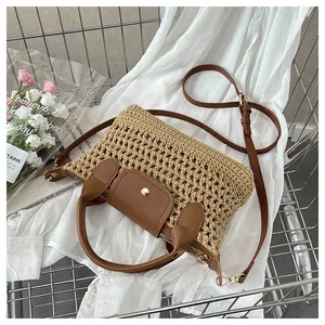 Details van de geweven textuur en bruine leren flap van de strooien crossbodytas