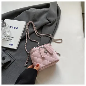 Detail of pink quilted leather box bag with silver flower clasp and woven chain strap
