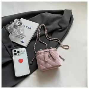 Detail of pink quilted leather box bag with dual floral zippers on grey suit fabric