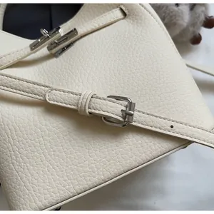 Dettaglio della borsa in pelle color crema con grana litchi e chiusura in metallo argento