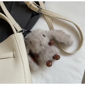 Dettaglio di un ciondolo a forma di coniglio su una borsa in pelle beige
