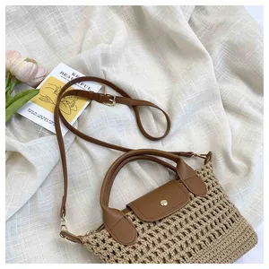 Detail van beige geweven tas met bruine leren handvatten en gouden metalen sluiting