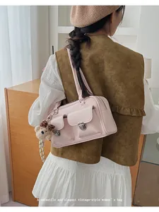 Détail du sac sous le bras rose vintage avec doubles poches et pendentif ours