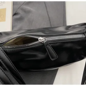 Detail shot of the silver metal zipper and inner lining of the black pillow bag