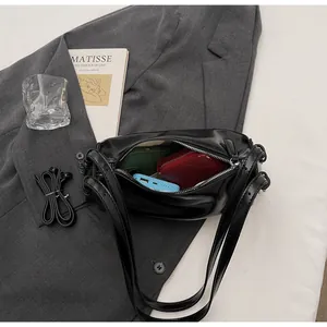 Internal view of black pillow bag showing large capacity for phone and wallet