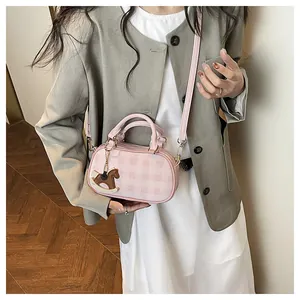 Detalle del bolso Boston de cuadros rosas con asas dobles y colgante de caballo