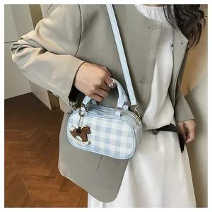 Bolso Boston de cuadros azules con colgante de caballo de madera lucido por modelo