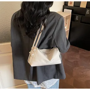 Detail of off-white minimalist leather pillow bag with adjustable shoulder straps
