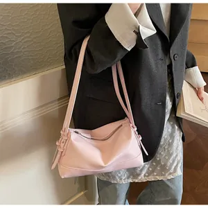 Pink pillow shoulder bag shown being worn with a chic grey suit and white top