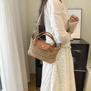 Geweven stro schoudertas met bruine lederen handvatten en klep in vintage zomerstijl