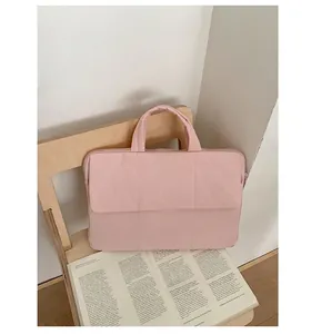 Pink quilted laptop bag featuring padded handles and a front pocket on a wooden chair