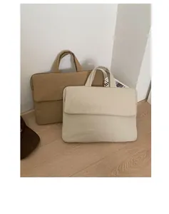 Close-up of quilted lightweight canvas laptop bags in khaki and beige for daily commute
