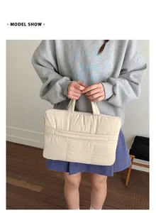 Detail of quilted beige laptop bag showing soft texture and handle for 13-14 inch laptop