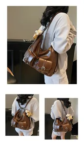 Detailansicht eines großen dunkelbraunen Lederrucksacks mit Utility-Taschen und Anhänger