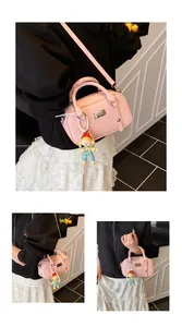 Roze handtas met litchi-nerf, verstelbare riem en een schattige poppenhanger