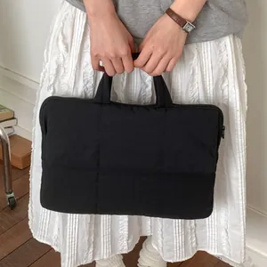 Minimalist black quilted laptop tote bag with sturdy handles for daily commute